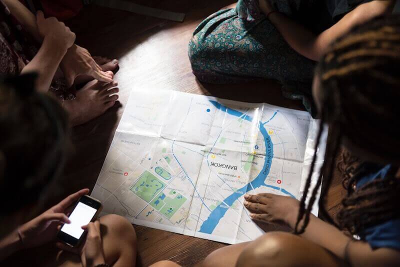 Backpackers poring over a map in a hostel