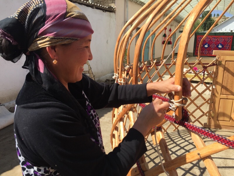 Woman setting up a yurt in Kyrgyzstan