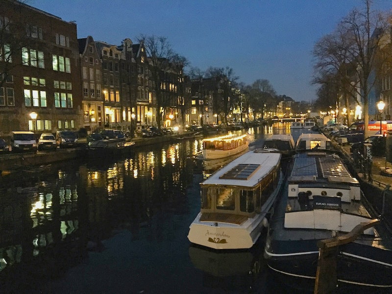 If you're traveling solo to Amsterdam, take a night canal cruise: boats floating along the canals at night
