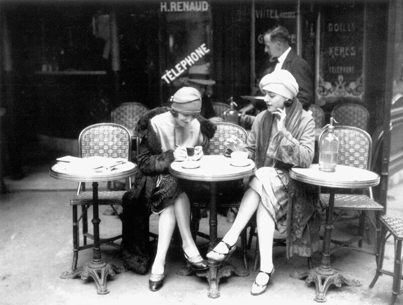 Historical photograph of a Paris café - women carrying their best purse for travel abroad