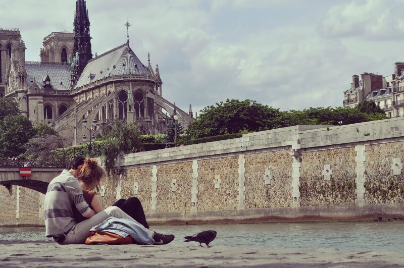 Kissing: not always culturally acceptable in public - a couple in the shadow of Notre-Dame in Paris